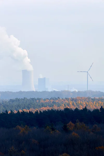 Coal powerplant next to a wind turbine