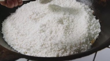 Aşçı büyük bir kazanda pirinci karıştırır. Plov Hazırlama.