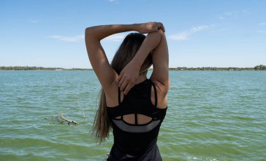 Genç bayan sporcu gölde geriniyor.