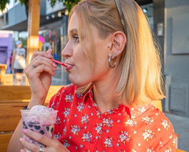 Güzel bir kadın dondurma yer. 