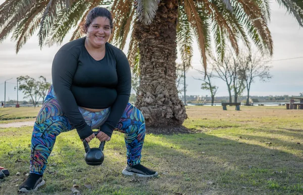 一个年轻的胖女人带着水壶在公园里锻炼 — 图库照片