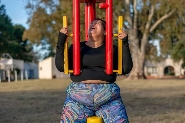 年轻的肥胖妇女正在做着胸部和肩膀的野蛮运动 — 图库照片
