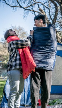 İki arkadaş kamp alanında çadır kurdular.