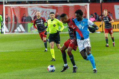 Toronto, ON, Kanada - 1 Nisan: Mark-Anthony Kaye # 14 Toronto FC (L) ve Derrick Jones # 20 Charlotte FC (R) orta saha oyuncusu, Toronto FC (Kanada) ve Charlotte FC (U) arasında oynanan 2023 MLS Normal Sezonu karşılaşmasında top için yarışıyor.