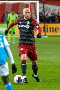 Toronto, ON, Kanada - 1 Nisan: Michael Bradley # 4 orta saha oyuncusu Toronto FC (Kanada) ve Charlotte FC (ABD) arasında oynanan 2023 MLS Normal Sezonu maçında top ile Toronto, Kanada 'daki BMO Field' da hareket ediyor (Score 2: 2)
