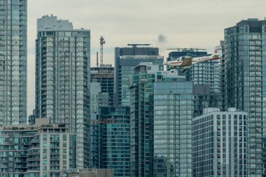 Toronto, ON, Kanada - 21 Ağustos 2022: CN Kulesi ve Toronto Skyline 'ın arka planında yer alan Grob G 115 uçağı, Billy Bishop Toronto Şehir Havaalanı' na inmek için yaklaşıyor.