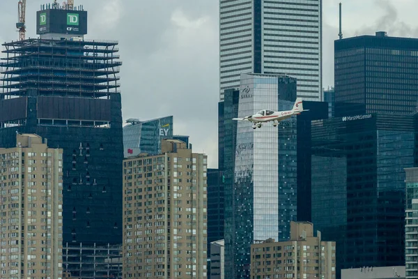 Toronto, ON, Kanada - 21 Ağustos 2022: CN Kulesi ve Toronto Skyline 'ın arka planında yer alan Grob G 115 uçağı, Billy Bishop Toronto Şehir Havaalanı' na inmek için yaklaşıyor.