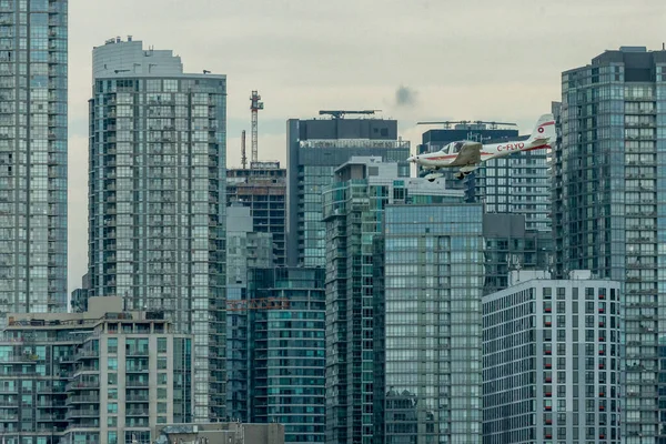 Toronto, ON, Kanada - 21 Ağustos 2022: CN Kulesi ve Toronto Skyline 'ın arka planında yer alan Grob G 115 uçağı, Billy Bishop Toronto Şehir Havaalanı' na inmek için yaklaşıyor.
