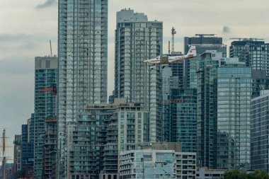 Toronto, ON, Kanada - 21 Ağustos 2022: CN Kulesi ve Toronto Skyline 'ın arka planında yer alan Grob G 115 uçağı, Billy Bishop Toronto Şehir Havaalanı' na inmek için yaklaşıyor.