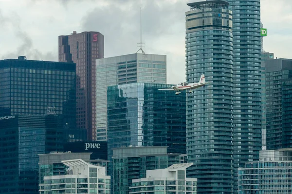 Toronto, ON, Kanada - 21 Ağustos 2022: CN Kulesi ve Toronto Skyline 'ın arka planında yer alan Grob G 115 uçağı, Billy Bishop Toronto Şehir Havaalanı' na inmek için yaklaşıyor.