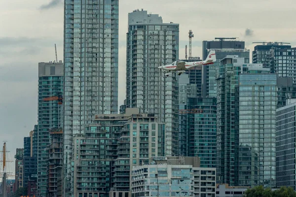 Toronto, ON, Kanada - 21 Ağustos 2022: CN Kulesi ve Toronto Skyline 'ın arka planında yer alan Grob G 115 uçağı, Billy Bishop Toronto Şehir Havaalanı' na inmek için yaklaşıyor.
