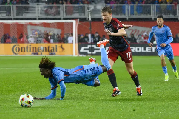 stock image Toronto, ON, Canada - May 11, 2024:  Sigurd Rosted #17 defender of Toronto FC knocks down Malachi Jones #88 forward of New York City FC in a tackle during MLS match between Toronto FC (Canada) and New York City FC (USA) at BMO Field