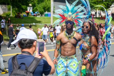 Toronto, ON, Kanada - 5 Ağustos 2023: Adam Toronto 'daki Caribana Geçit Töreni için ışıl ışıl giyinmiş katılımcının fotoğrafını çekti