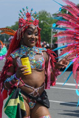 Toronto, ON, Kanada - 5 Ağustos 2023: Toronto 'daki Caribana Geçit Töreni için gösterişli tüylü geçit töreni kostümü giyen katılımcı