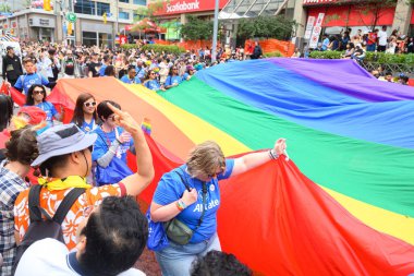 Toronto, ON, Kanada 30 Haziran 2024: Onur Yürüyüşü sırasında LGBT gururunun bir sembolü olarak büyük bir gökkuşağı bayrağı taşıyacak.