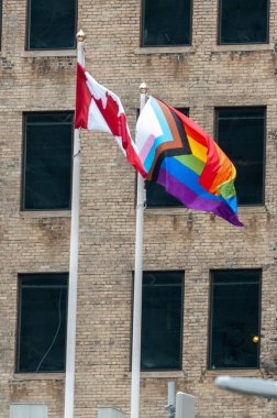 Toronto, ON, Kanada 30 Haziran 2024: Onur bayrağı, Onur Yürüyüşü sırasında bir bayrak direğinde LGBT gururunun ve Kanada bayrağının bir sembolüdür..