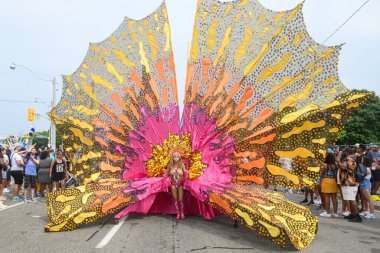 Toronto, ON, Kanada - 3 Ağustos 2024: renkli kostümlü geçit katılımcısı Toronto Karayip Karnavalı Büyük Geçit Töreni 'nde şamandıra çekti.