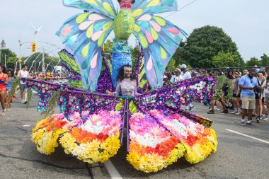 Toronto, ON, Kanada - 3 Ağustos 2024: renkli kostümlü geçit katılımcısı Toronto Karayip Karnavalı Büyük Geçit Töreni 'nde şamandıra çekti.