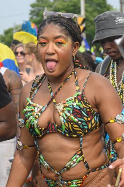 Toronto, ON, Kanada - 3 Ağustos 2024: Toronto 'daki Caribana Geçit Töreni için gösterişli tüylü geçit töreni kostümü giyen katılımcı