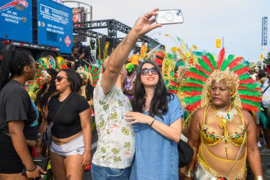 Toronto, ON, Kanada - 3 Ağustos 2024: Toronto 'daki Caribana Geçit Töreni için gösterişli tüylü geçit töreni kostümü giyen katılımcı
