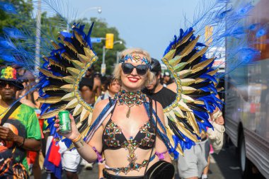 Toronto, ON, Kanada - 3 Ağustos 2024: Toronto 'daki Caribana Geçit Töreni için gösterişli tüylü geçit töreni kostümü giyen katılımcı