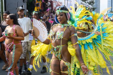 Toronto, ON, Kanada - 3 Ağustos 2024: Toronto 'daki Caribana Geçit Töreni için gösterişli tüylü geçit töreni kostümü giyen katılımcı
