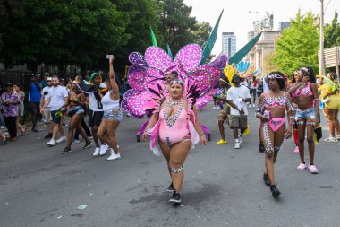 Toronto, ON, Kanada - 3 Ağustos 2024: Toronto 'daki Caribana Geçit Töreni için gösterişli tüylü geçit töreni kostümü giyen katılımcı