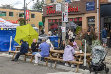 Toronto, ON, Kanada - 7 Eylül 2024: Geleneksel Kingsway 2024 Sokak Festivali 'nin tadını çıkaran insanlar