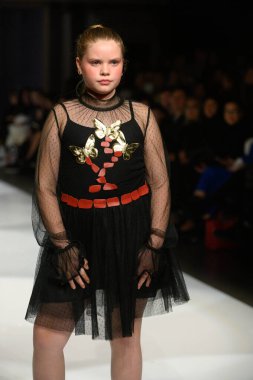 Toronto, ON, Kanada - 7 Aralık 2024: Toronto Çocuk Moda Haftası sırasında Olesia Lazovaia koleksiyonunda bir model podyumda yürüyor