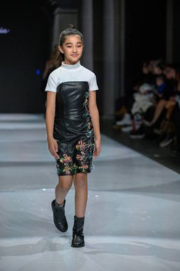 Toronto, ON, Kanada - 7 Aralık 2024: Toronto Çocuk Moda Haftası sırasında Olesia Lazovaia koleksiyonunda bir model podyumda yürüyor