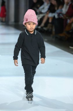 Toronto, ON, Kanada - 7 Aralık 2024: Toronto Çocuk Moda Haftası 'nda bir model Retro Kid koleksiyonunda podyumda yürüyor.