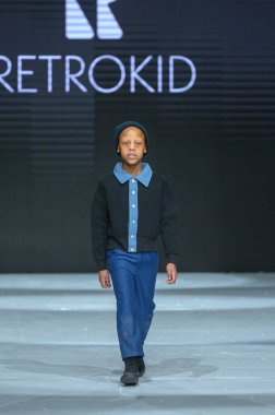 Toronto, ON, Kanada - 7 Aralık 2024: Toronto Çocuk Moda Haftası 'nda bir model Retro Kid koleksiyonunda podyumda yürüyor.
