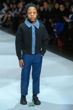 Toronto, ON, Kanada - 7 Aralık 2024: Toronto Çocuk Moda Haftası 'nda bir model Retro Kid koleksiyonunda podyumda yürüyor.