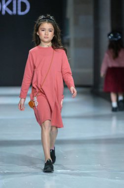 Toronto, ON, Kanada - 7 Aralık 2024: Toronto Çocuk Moda Haftası 'nda bir model Retro Kid koleksiyonunda podyumda yürüyor.