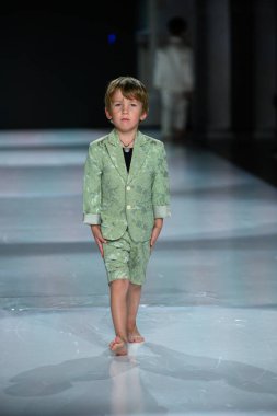 Toronto, ON, Kanada - 7 Aralık 2024: Toronto Çocuk Moda Haftası 'nda Yurt Çocukları Moda Koleksiyonu' nda bir model podyumda yürüyor.