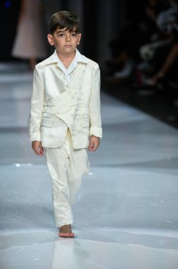 Toronto, ON, Kanada - 7 Aralık 2024: Toronto Çocuk Moda Haftası 'nda Yurt Çocukları Moda Koleksiyonu' nda bir model podyumda yürüyor.