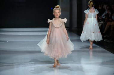 Toronto, ON, Kanada - 7 Aralık 2024: Toronto Çocuk Moda Haftası 'nda Yurt Çocukları Moda Koleksiyonu' nda bir model podyumda yürüyor.