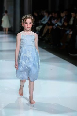 Toronto, ON, Kanada - 7 Aralık 2024: Toronto Çocuk Moda Haftası 'nda Yurt Çocukları Moda Koleksiyonu' nda bir model podyumda yürüyor.