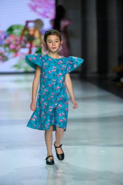 Toronto, ON, Kanada - 7 Aralık 2024: Toronto Çocuk Moda Haftası sırasında Javeda Bebek Koleksiyonu 'nda bir model podyumda yürüyor.