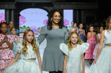 Toronto, ON, Kanada - 7 Aralık 2024: Tasarımcı Toronto Çocuk Moda Haftası 'nda tasarımlarını gösterdikten sonra podyuma çıktı.