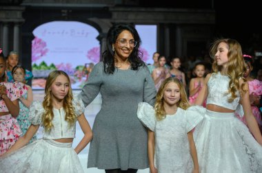 Toronto, ON, Kanada - 7 Aralık 2024: Tasarımcı Toronto Çocuk Moda Haftası 'nda tasarımlarını gösterdikten sonra podyuma çıktı.
