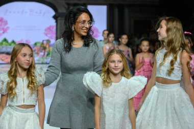 Toronto, ON, Kanada - 7 Aralık 2024: Tasarımcı Toronto Çocuk Moda Haftası 'nda tasarımlarını gösterdikten sonra podyuma çıktı.