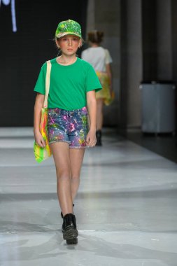 Toronto, ON, Kanada - 7 Aralık 2024: Toronto Çocuk Moda Haftası Moda Şovu sırasında bir manken Rain On Me (ROM) koleksiyonunda podyumda yürüyor.