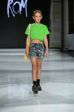 Toronto, ON, Kanada - 7 Aralık 2024: Toronto Çocuk Moda Haftası Moda Şovu sırasında bir manken Rain On Me (ROM) koleksiyonunda podyumda yürüyor.