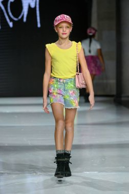 Toronto, ON, Kanada - 7 Aralık 2024: Toronto Çocuk Moda Haftası Moda Şovu sırasında bir manken Rain On Me (ROM) koleksiyonunda podyumda yürüyor.