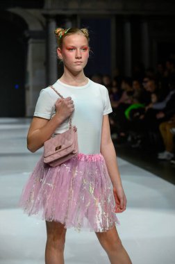 Toronto, ON, Kanada - 7 Aralık 2024: Toronto Çocuk Moda Haftası Moda Şovu sırasında bir manken Rain On Me (ROM) koleksiyonunda podyumda yürüyor.