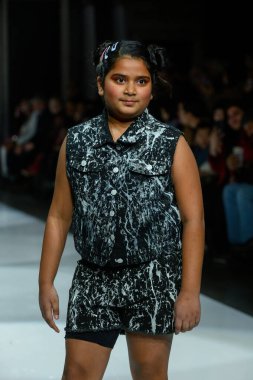 Toronto, ON, Kanada - 7 Aralık 2024: Toronto Çocuk Moda Haftası Moda Şovu sırasında bir manken Rain On Me (ROM) koleksiyonunda podyumda yürüyor.