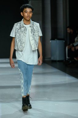 Toronto, ON, Kanada - 7 Aralık 2024: Toronto Çocuk Moda Haftası Moda Şovu sırasında bir manken Rain On Me (ROM) koleksiyonunda podyumda yürüyor.