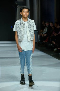 Toronto, ON, Kanada - 7 Aralık 2024: Toronto Çocuk Moda Haftası Moda Şovu sırasında bir manken Rain On Me (ROM) koleksiyonunda podyumda yürüyor.