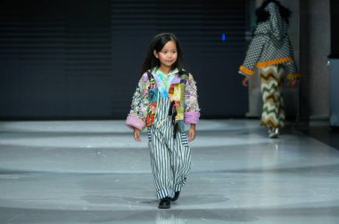 Toronto, ON, Kanada - 7 Aralık 2024: Toronto Çocuk Moda Haftası 'nda IANI koleksiyonunda bir model podyumda yürüyor.